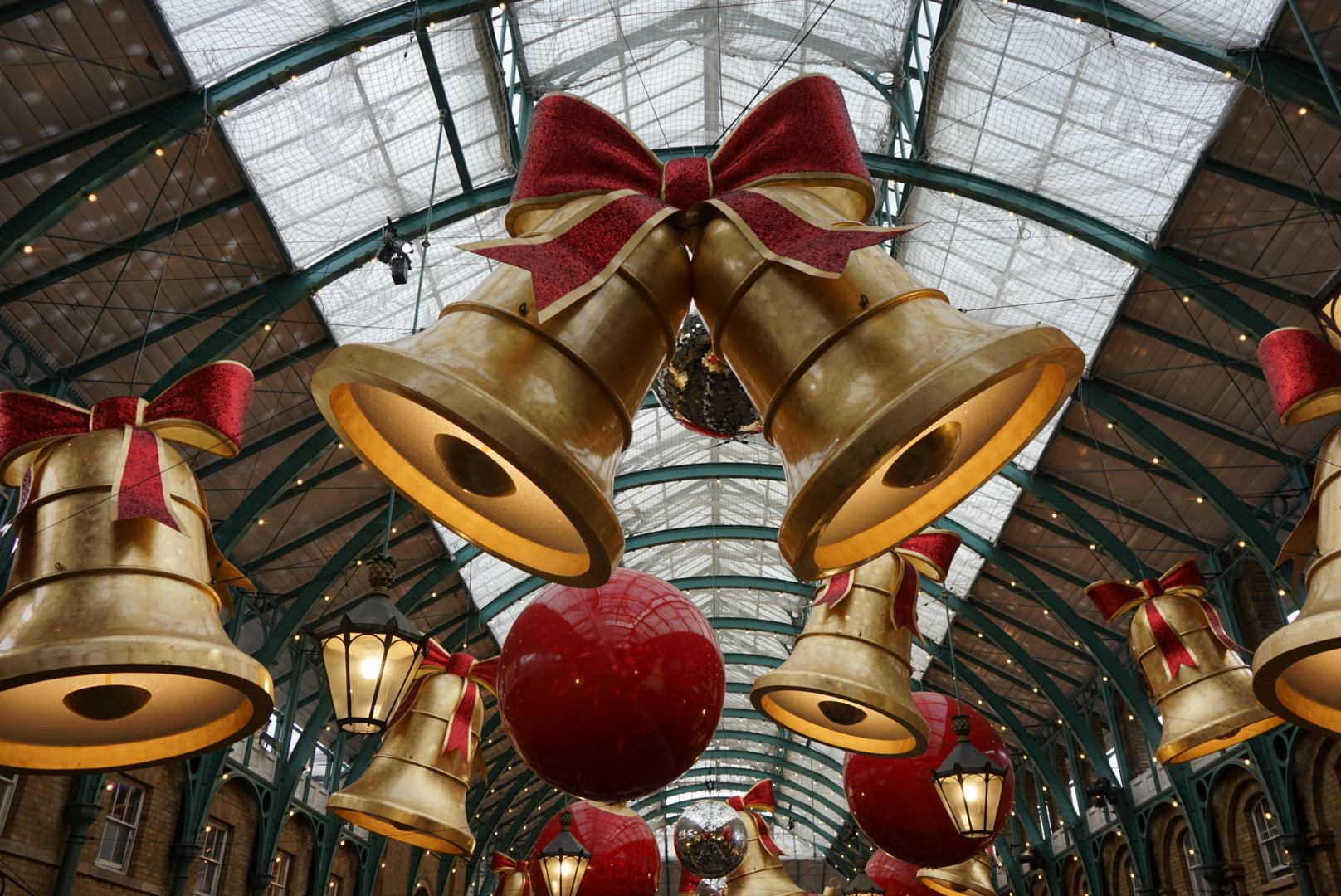 Die goldenen Glocken mit roter Schleife in der Halle des Covent Garden in London zur Weihnachtszeit