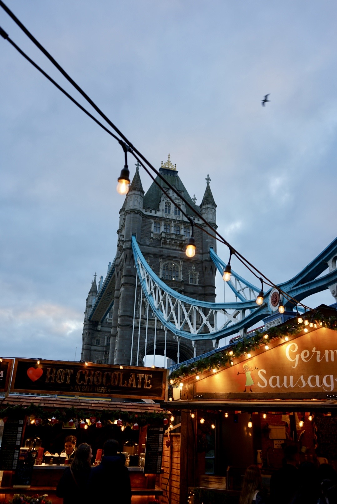 Blick auf die Tower Bridge in London mit einem Weihnachtsmarkt im Vordergrund