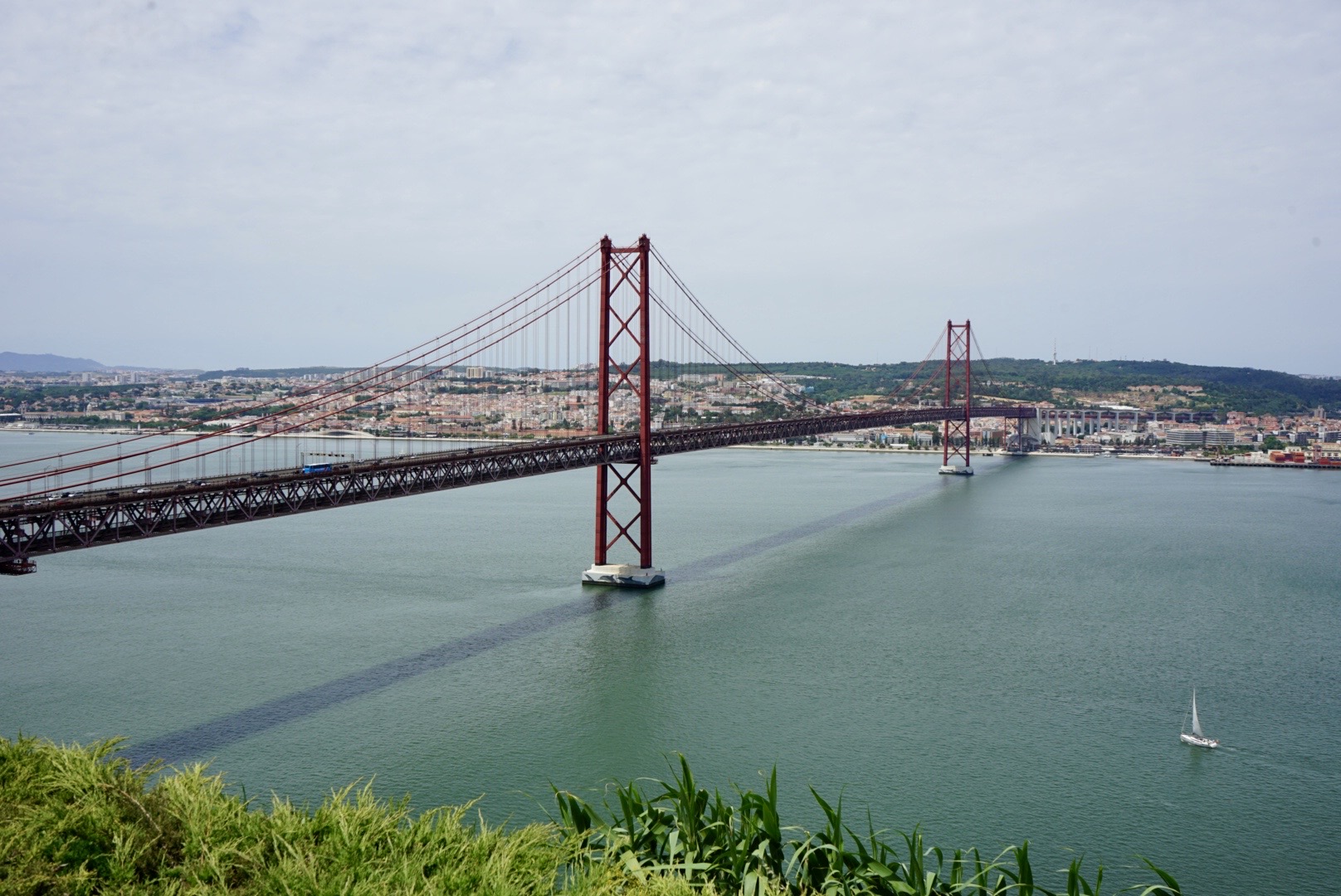 Die wunderschöne Ponte 25 de Abril in Lissabon bei strahlendem Sonnenschein mit Blick auf die Stadt