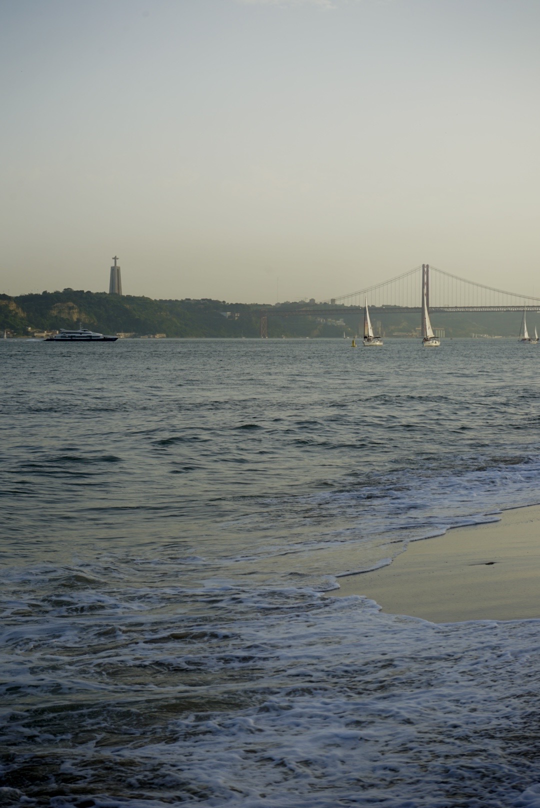 Am Ufer nahe des Arco da Rua Augusta mit Blick auf die Cristo-Rei Statua und die Brücke